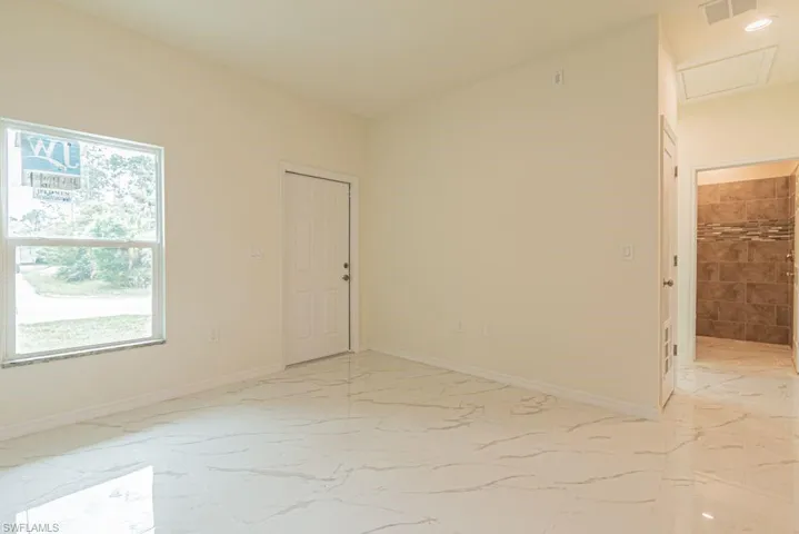 Tiled empty room featuring a wealth of natural light