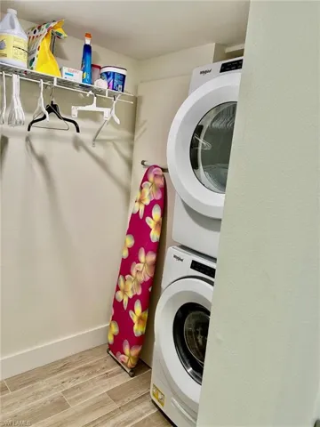 Laundry room with stacked washer / dryer and light hardwood / wood-style floors