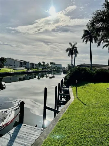 Dock area with a water view and a yard
