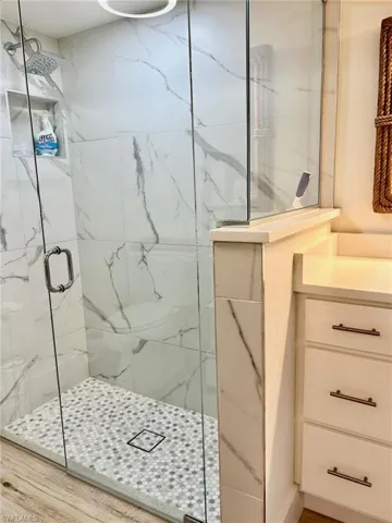 Bathroom featuring vanity, walk in shower, and hardwood / wood-style floors