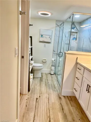 Bathroom featuring hardwood / wood-style flooring, toilet, and vanity