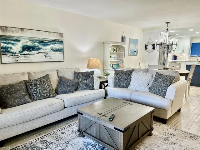 Living room featuring light hardwood / wood-style floors and a notable chandelier