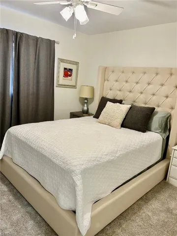 Bedroom with ceiling fan and light colored carpet