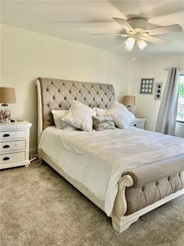 Bedroom with light colored carpet and ceiling fan