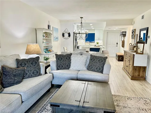 Living room with light hardwood / wood-style flooring and an inviting chandelier