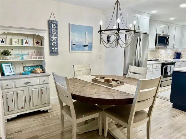 Dining space with a chandelier and light hardwood / wood-style flooring