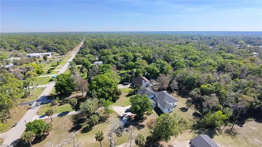 Aerial view of property and surrounding area featuring a heavily wooded area