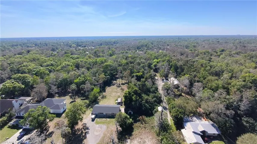Aerial view of property and surrounding area featuring a heavily wooded area