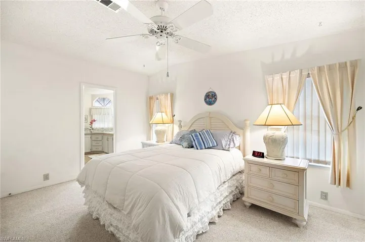 Bedroom with visible vents, multiple windows, and light colored carpet