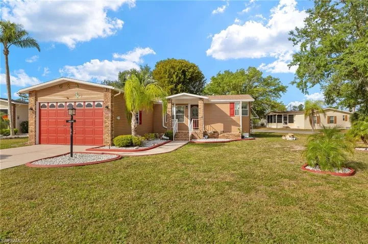 View of front of property featuring a front yard, driveway, and an attached garage