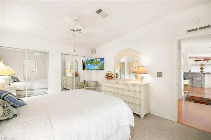 Bedroom with light carpet, ceiling fan, baseboards, and visible vents