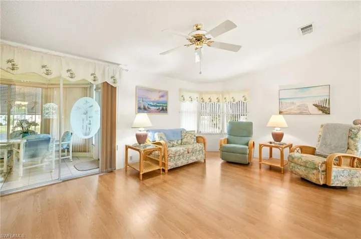 Sitting room with visible vents, a ceiling fan, wood finished floors, and a textured ceiling