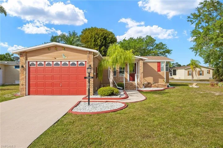 Single story home with a front yard, an attached garage, and concrete driveway