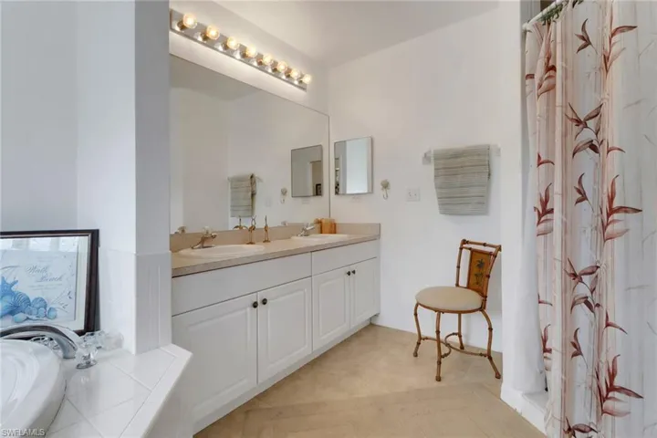 Full bathroom with double vanity, a sink, and a bathtub