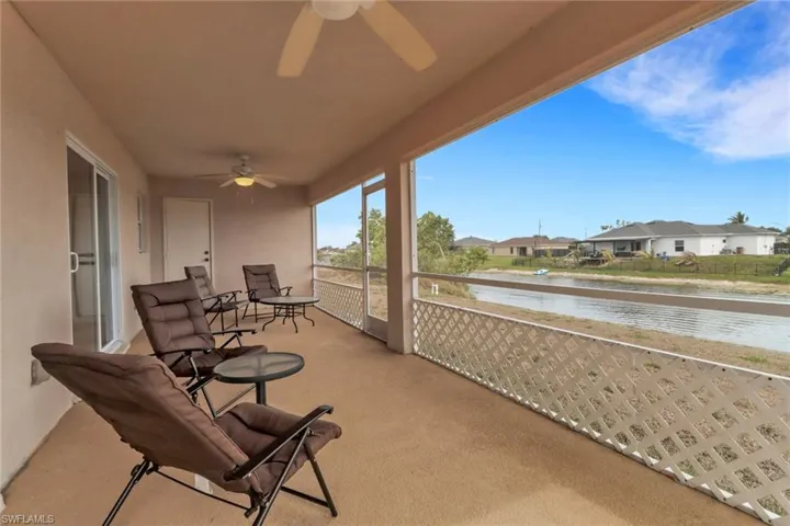 Balcony with a ceiling fan, a residential view, and a water view