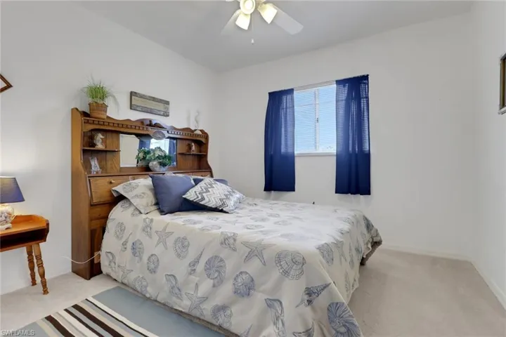Carpeted bedroom with baseboards and ceiling fan