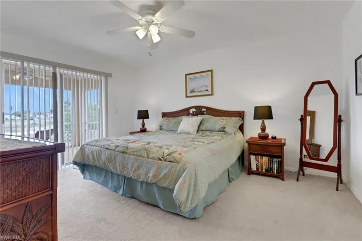 Carpeted bedroom with baseboards, a ceiling fan, and access to exterior