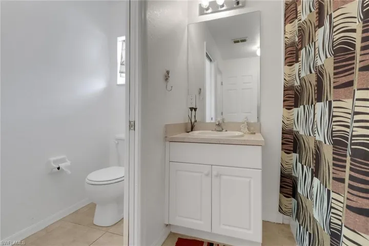 Bathroom featuring visible vents, tile patterned flooring, toilet, and vanity