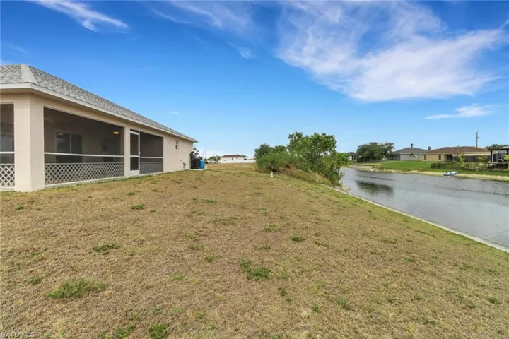 View of yard featuring a water view and a sunroom