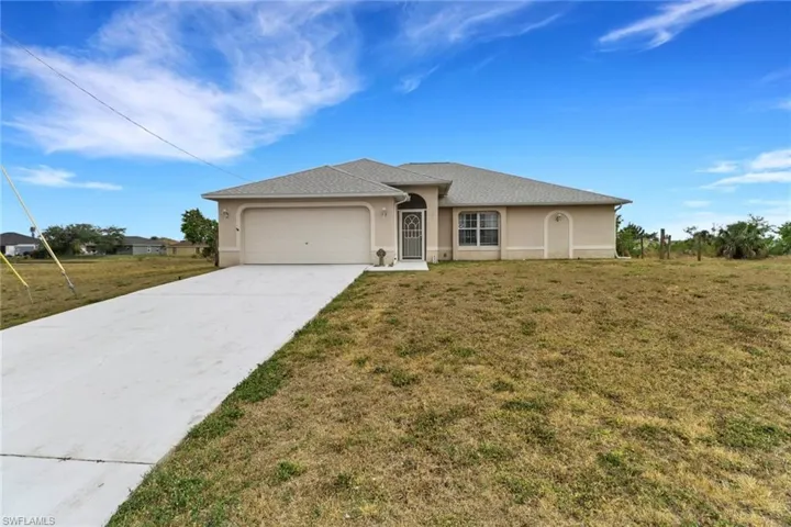 Single story home with an attached garage, stucco siding, driveway, and a front yard