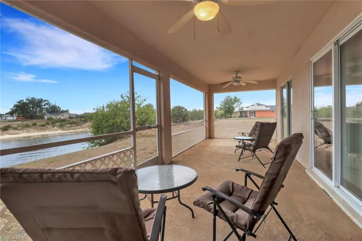 Sunroom featuring a water view and a ceiling fan