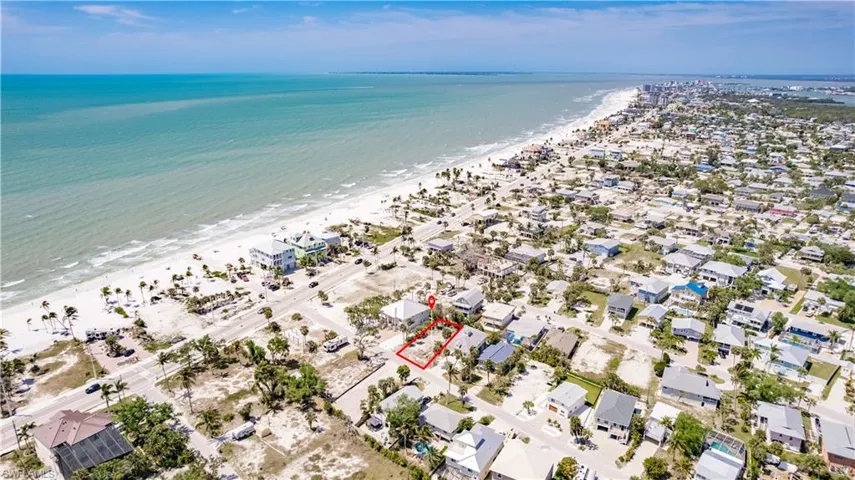 Birds eye view of property featuring a beach view and a water view