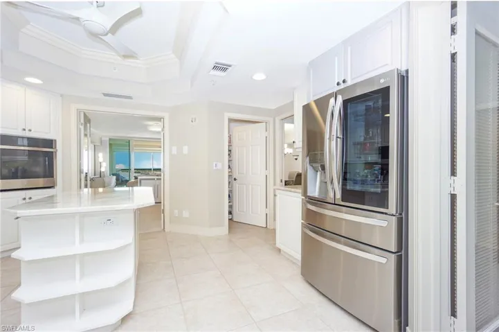 Kitchen featuring crown molding, stainless steel appliances, a kitchen island, and white cabinets