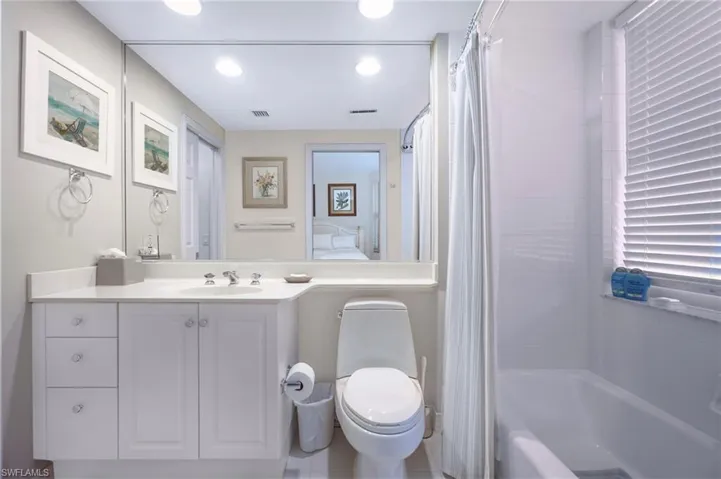 Full bathroom featuring vanity, shower / bath combo, and toilet