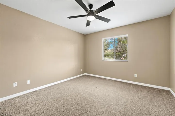 Unfurnished room with ceiling fan and carpet floors