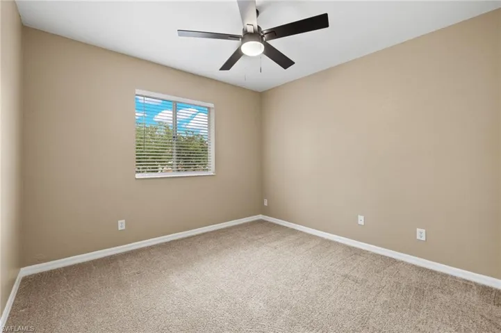Unfurnished room featuring ceiling fan and carpet floors