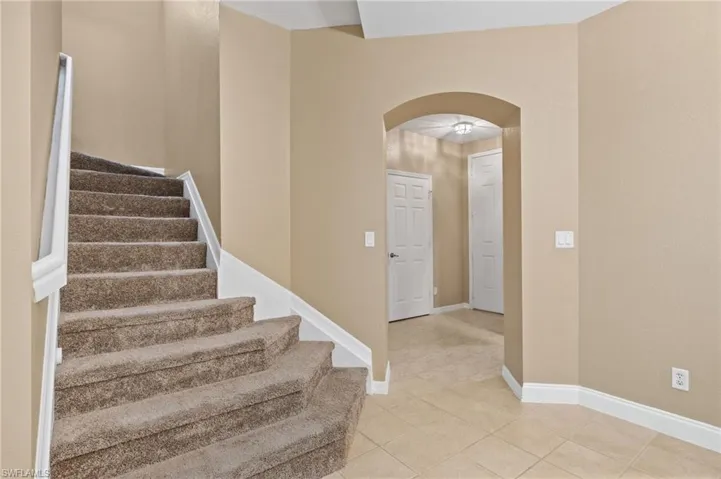 Foyer entrance featuring light tile patterned floors and ceiling fan