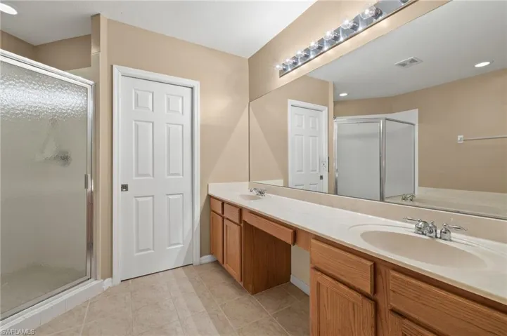 2nd floor Bathroom featuring dual bowl vanity, a shower with door, and tile patterned flooring