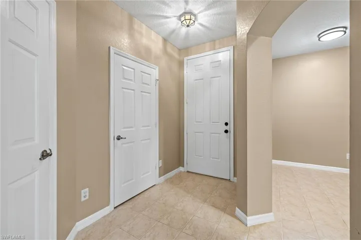 Entrance foyer with a textured ceiling and light tile patterned floors