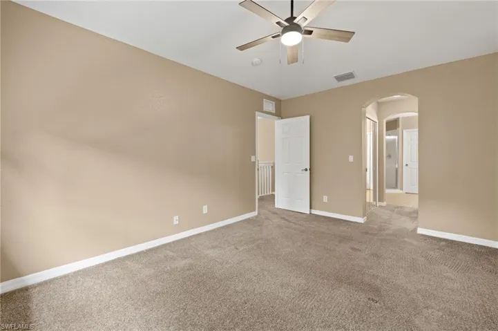 Carpeted spare room with ceiling fan