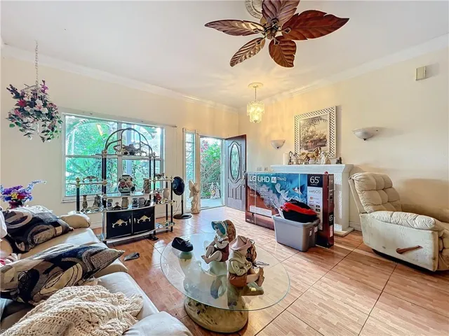 Living room with a wealth of natural light, a ceiling fan, and crown molding