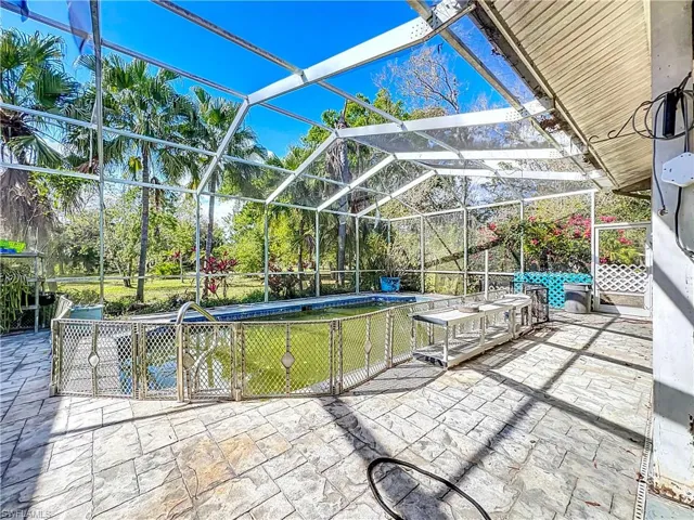 View of patio / terrace with an outdoor pool and a lanai
