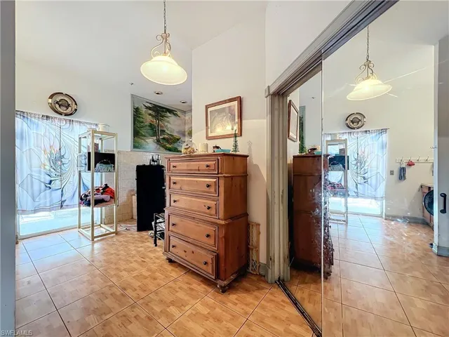 Hallway with light tile patterned flooring and a towering ceiling