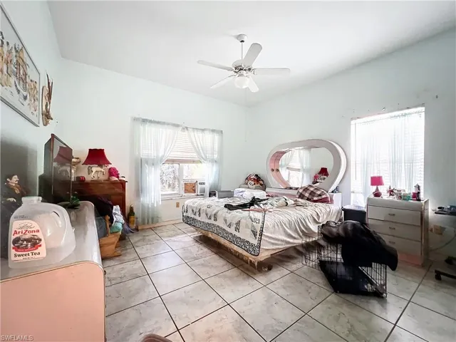 Bedroom with light tile patterned flooring, lofted ceiling, and a ceiling fan