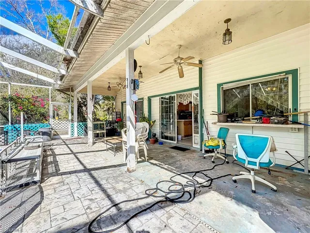 View of patio with glass enclosure and ceiling fan