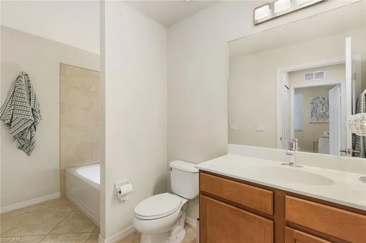 Guest bath with shower over tub and laundry area.
