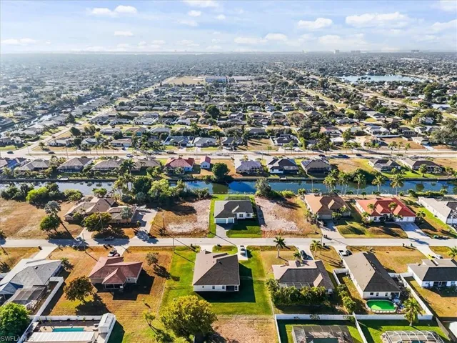 Aerial view of property and surrounding area with nearby suburban area