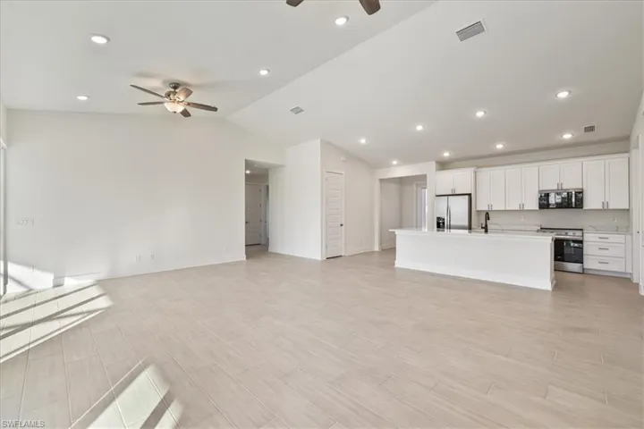 Unfurnished living room with recessed lighting, wood finish floors, lofted ceiling, and a ceiling fan