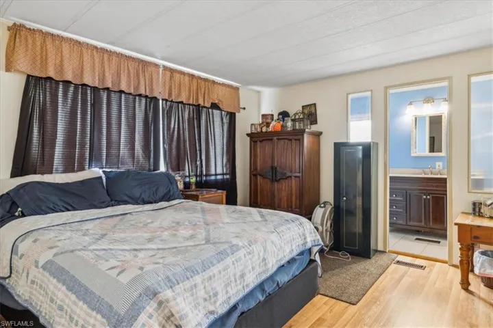 Bedroom featuring light wood-type flooring and connected bathroom