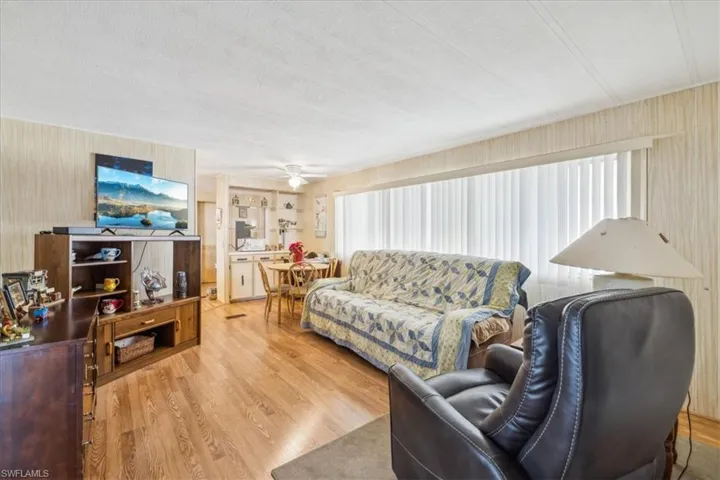 Living area with wood finished floors, ceiling fan, and a textured ceiling