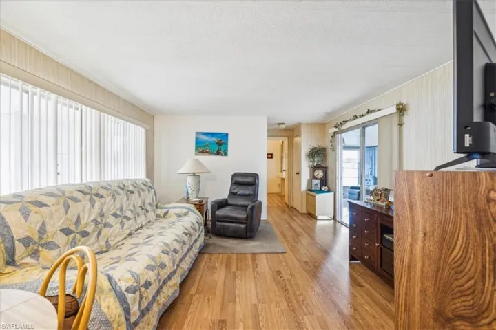 Living room featuring light wood-type flooring and a textured ceiling