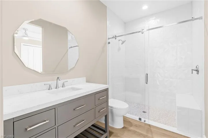 Bathroom featuring vanity, a stall shower, and light wood finished floors