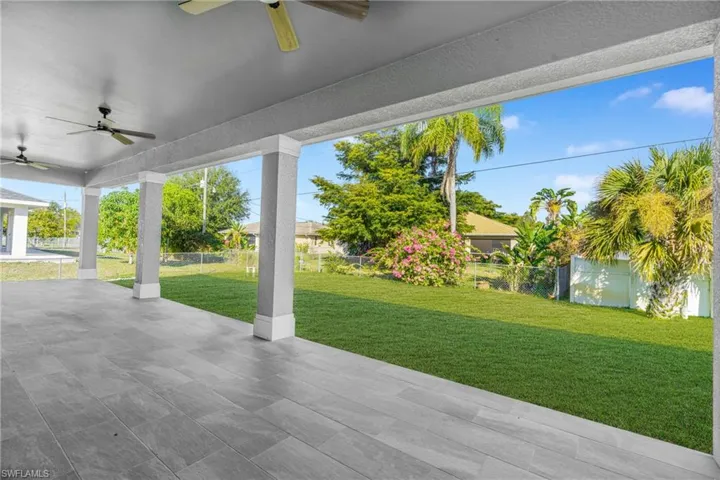 Fenced backyard featuring ceiling fan and a patio
