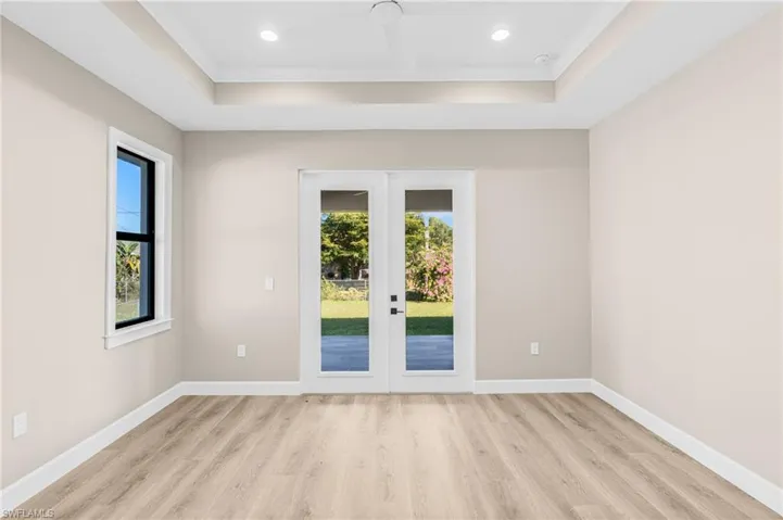 Master Suite with plenty of natural light, french doors, light wood-style floors, crown molding, and recessed lighting
