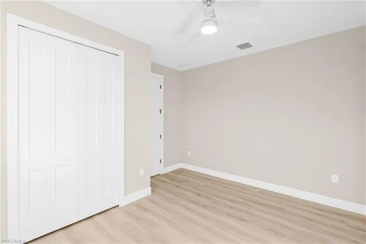 Unfurnished bedroom featuring a closet, light wood-type flooring, and a ceiling fan