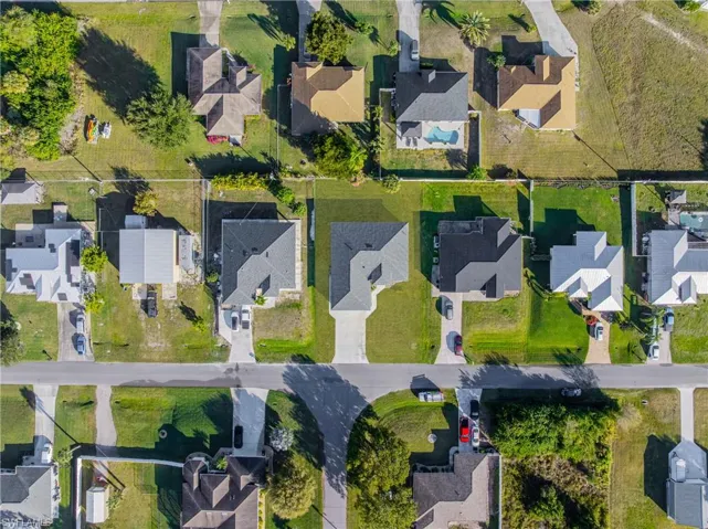 Aerial view of property and surrounding area featuring nearby suburban area
